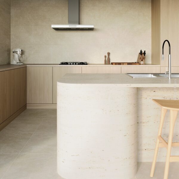 Cuisine moderne en travertin et bois clair. Îlot central incurvé, crédence beige, hotte aspirante SAMSUNG, et tabouret bois.