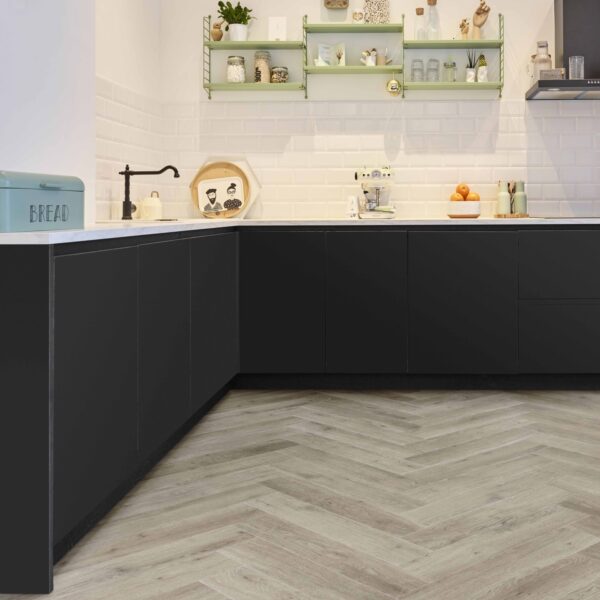 Cuisine moderne avec armoires basses noires, carrelage blanc, étagères String vertes et sol en bois clair à chevrons.