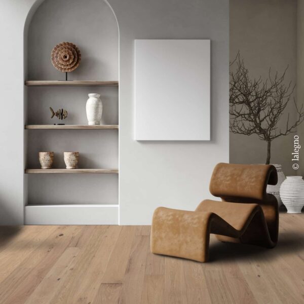 Fauteuil design en cuir tan sur parquet chêne clair. Niche murale arquée moderne avec étagères bois et décoration bohème.