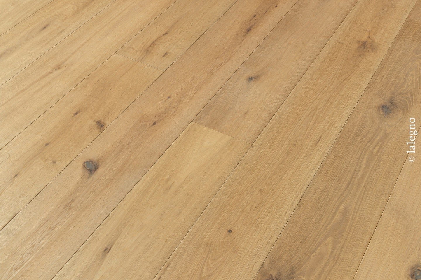Parquet chêne blond rustique, lames larges, posé en diagonale. Finition huilée mate avec nœuds visibles. © lalegno.
