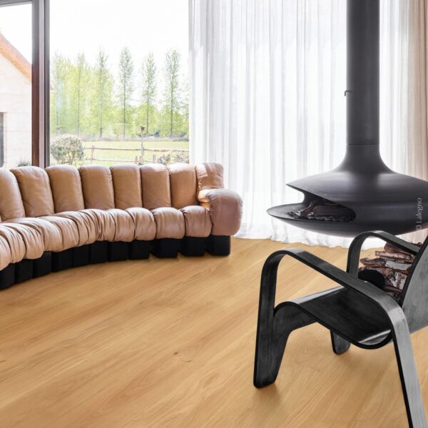 Parquet chêne clair dans un salon moderne. Canapé modulaire, fauteuil noir et foyer suspendu design. Vue sur la nature. © Lalegno.