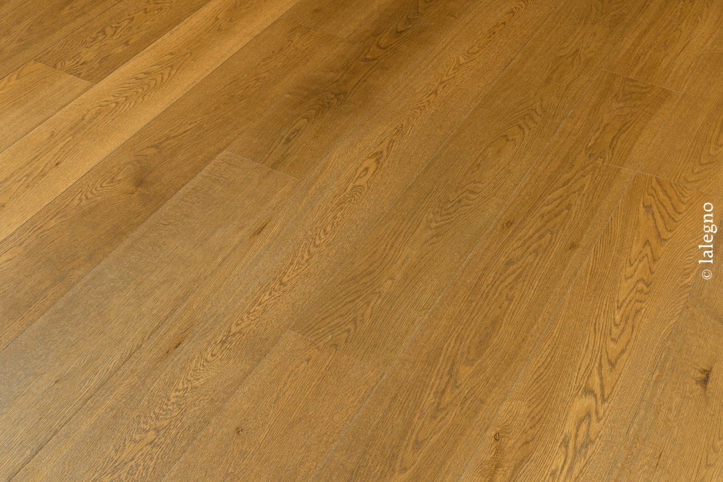 Parquet chêne naturel lames larges, teinte miel dorée et veinage marqué, posé en diagonale. Copyright lalegno visible.