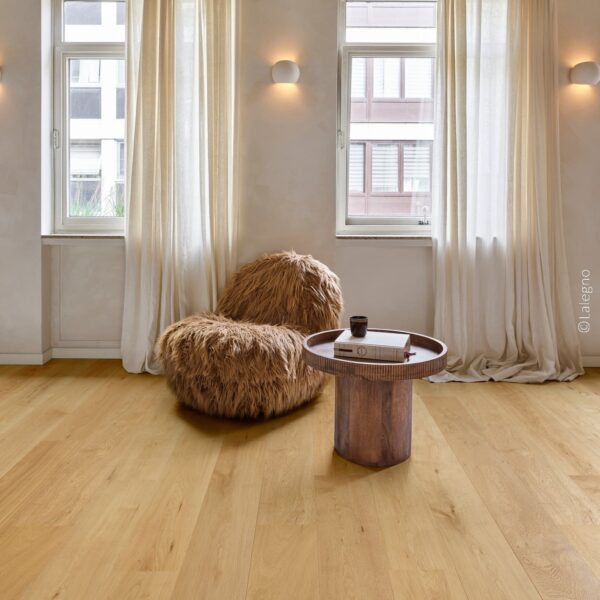 Parquet chêne naturel clair et fauteuil fourrure marron dans un intérieur style industriel. Lumière chaude et rideaux lin.