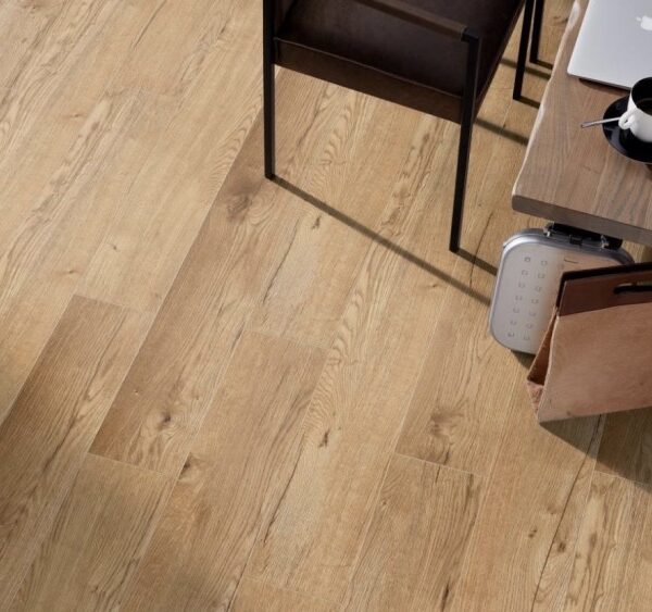 Plancher en bois de chêne clair avec lattes visibles, installé en diagonale sous un bureau moderne avec ordinateur, café et chaise.