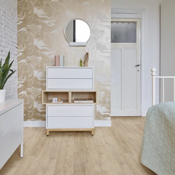 Plancher chêne clair dans une chambre. Commode blanche et mur d'accent marbré beige-doré. Ambiance moderne et lumineuse.